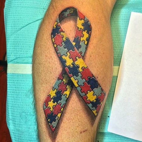 At sprede et budskab Mange gange bruges tatoveringer til at sprede bevidsthed om en årsag. Denne tatovering repræsenterer autisme bevidsthed.