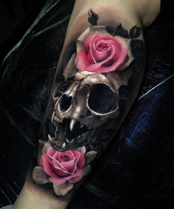 Vasikan tatuointi vaaleanpunaisilla ruusuilla ja kissan kallo mustalla ja harmaalla tyylillä