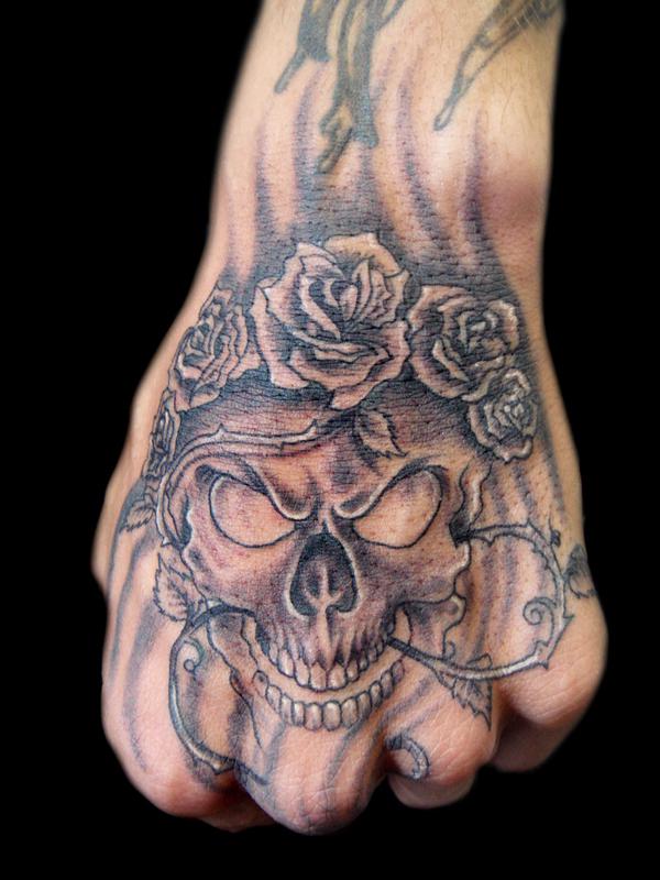Κρανίο και τριαντάφυλλα με τατουάζ αγκάθι στο χέρι