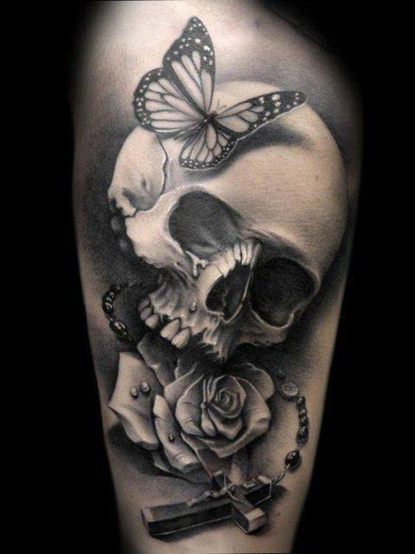 Sort og grå tatovering med kranium, sommerfugl, kors og rosenkrans