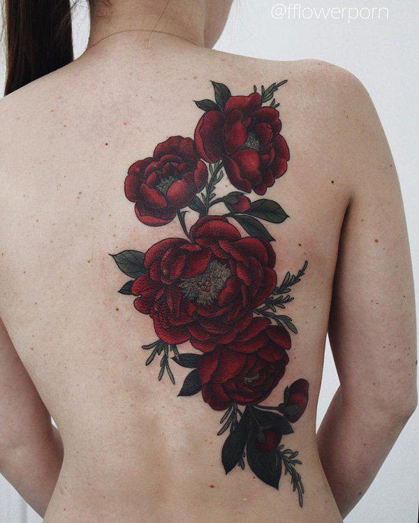 Burgundin ruusujen tatuointi naisen takana