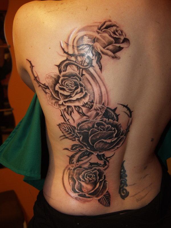 Harmaat ruusut, joiden takana on piikki -tatuointi