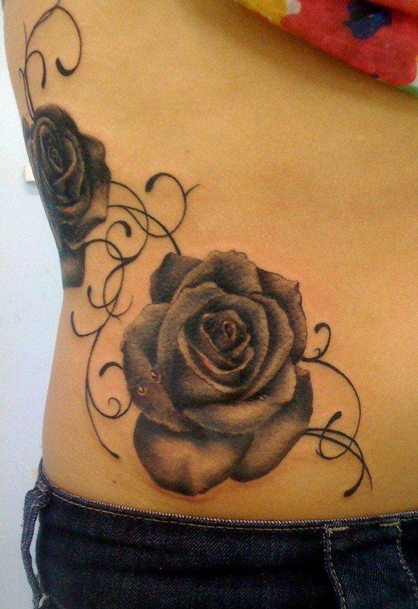 Harmaat ruusut ja viiniköynnöksen tatuointi selässä