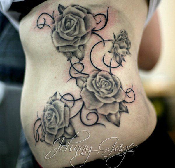 Neljä ruusua viiniköynnösten tatuoinnilla kylkiluun