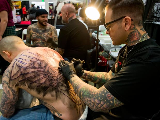 Tatuointitaiteilija Dan Smith, oikea, Captured Tattoo in Tustin -tatuointiasiakas Steve Brennan, joka matkusti kotoaan Washington DC: stä saadakseen Smithin tekemään tatuointinsa.
