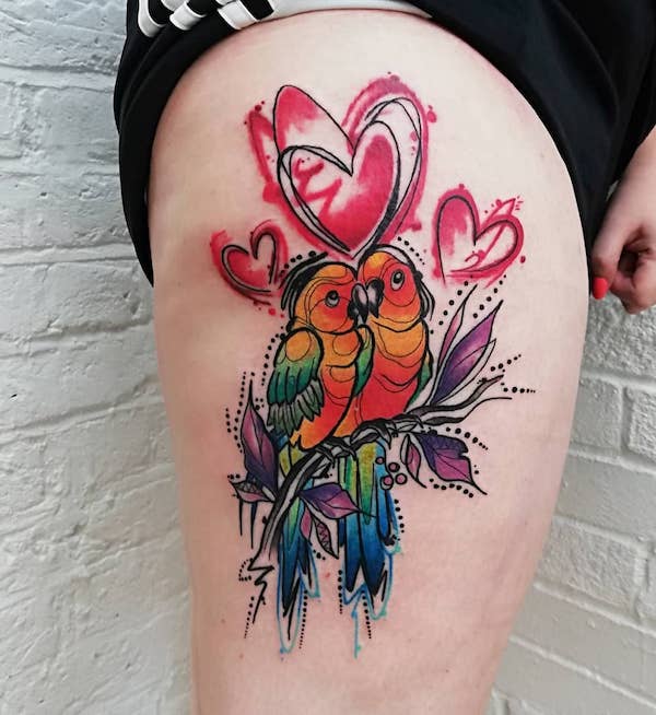 Vesiväri lovebird -tatuointi reiteen