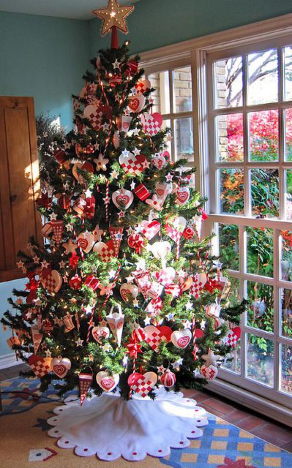 υπέροχο χριστουγεννιάτικο δέντρο διακοσμημένο με κόκκινα θεματικά στολίδια παγωτά ελεγμένα καρδιές