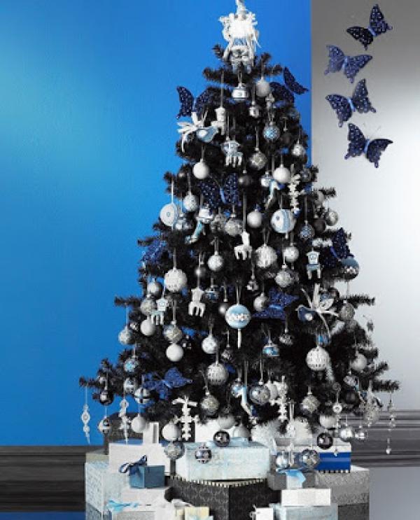 hopean sininen joulukuusi, joka on koristeltu epätavallisella koriste-perhosella