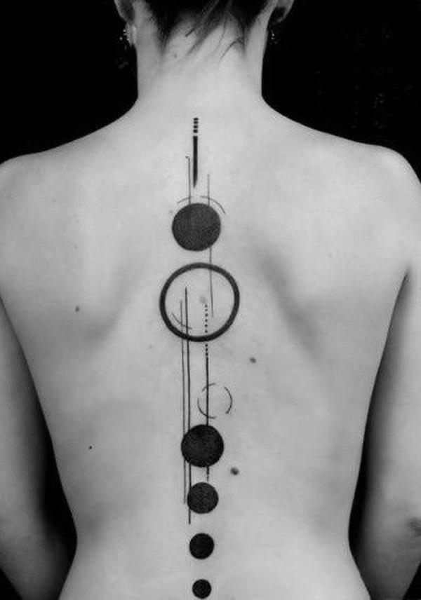 Abstrakt tatovering med prikker og cirkler som stjerner langs rygsøjlen