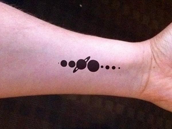 Silhuet tatovering med planeter i en lige linje på håndleddet