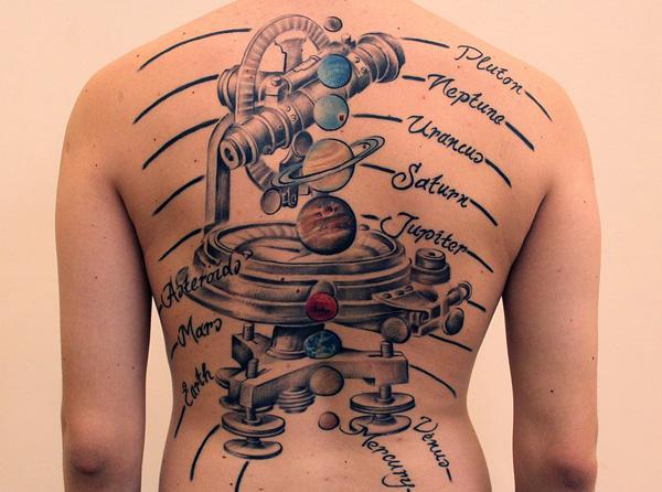En tatovering med fuld ryg med et instrument, der simulerer planeter