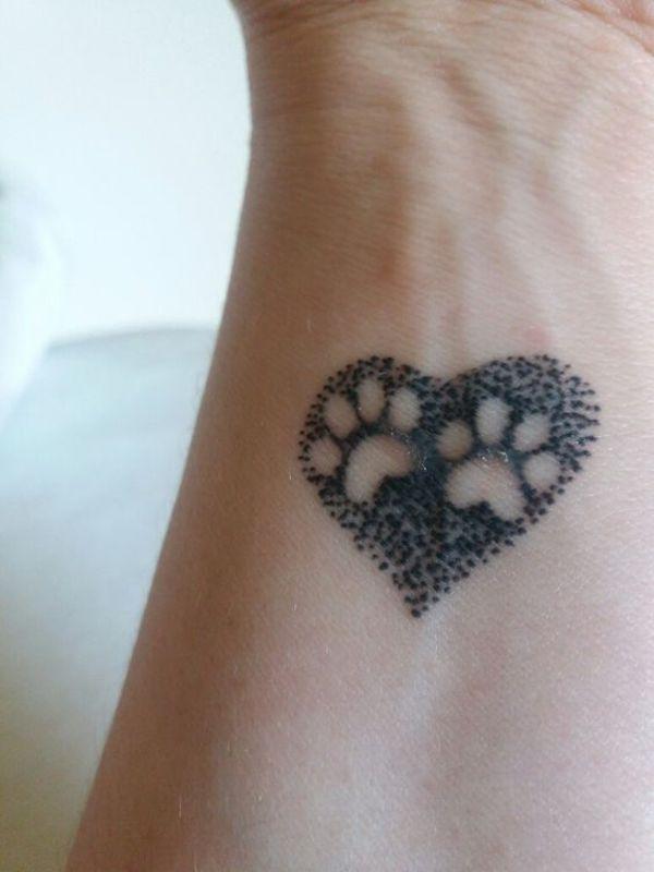 To poteprint i hjerteformet dotwork -tatovering på håndleddet
