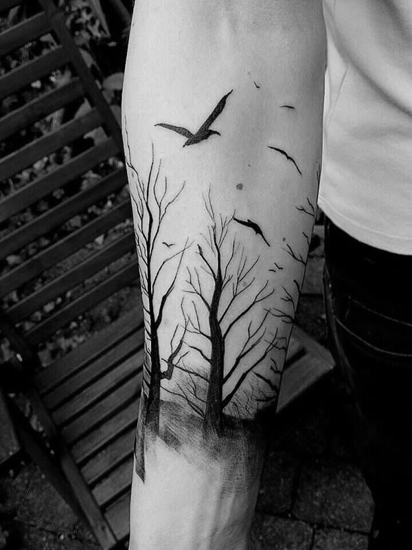 Silhuet tatovering med skov og fugle