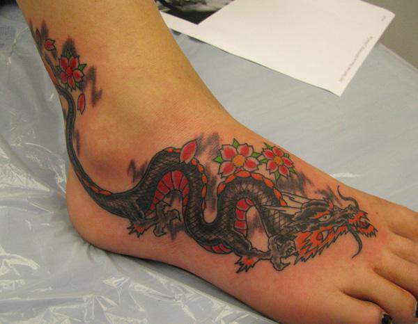Värikäs lohikäärmeen tatuointi jalalle naisille
