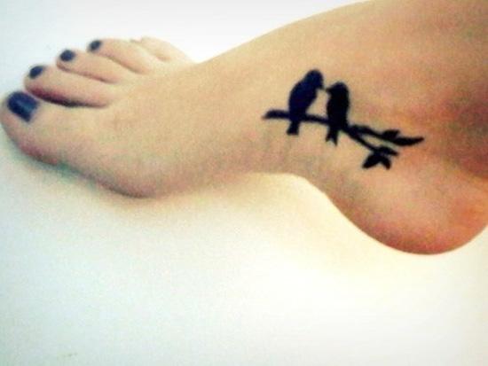 Silhouette -tatuointi, jossa on kaksi lovebirdia oksalla