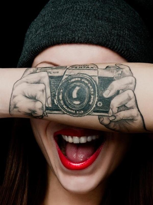Απατηλά χέρια που κρατούν τατουάζ κάμερας