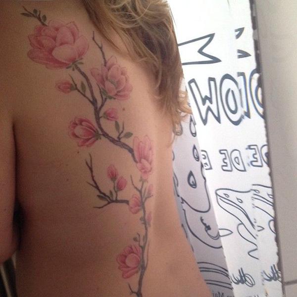 Magnolian kukka -tatuointi selässä