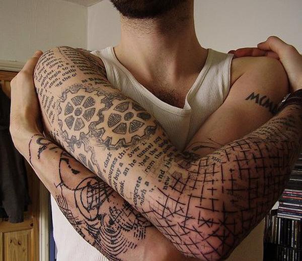 Monimutkainen täyshihainen tatuointi, jossa on monimutkaisia ​​käsikirjoituksia ja varoitusmerkkejä miehille