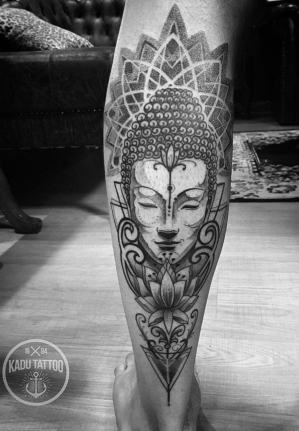 Harmaasävyinen tatuointi, jossa on Buddha, lootus ja mandala vasikalla