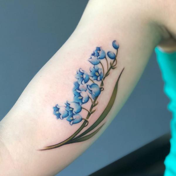 blå liljekonvaljstatovering på armen