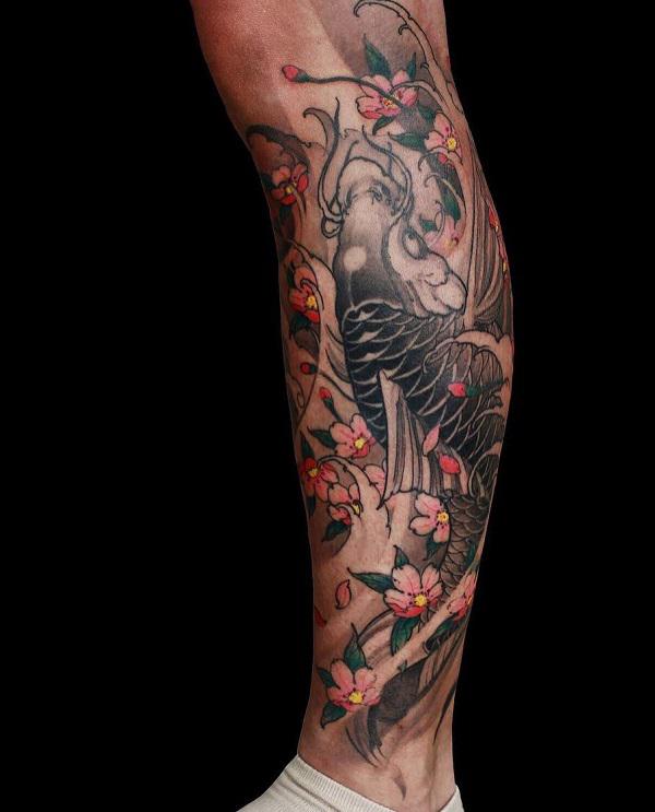 Ben tatovering med Kio fisk og kirsebærblomst