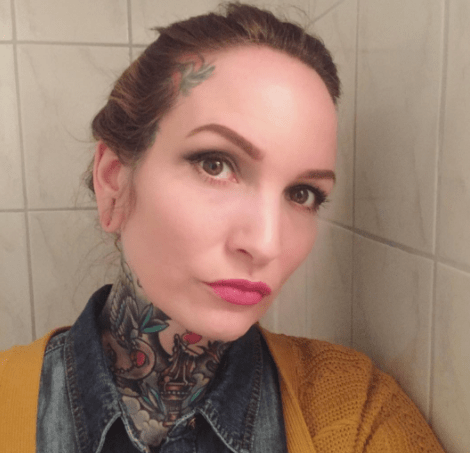 selfie naisesta täyskaulaisella tatuoinnilla