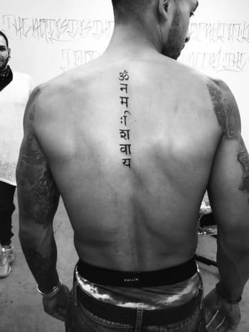 Theo Walcotts tatovering begynder lige under bunden af ​​hans hals, og karaktererne skulle oversættes til 