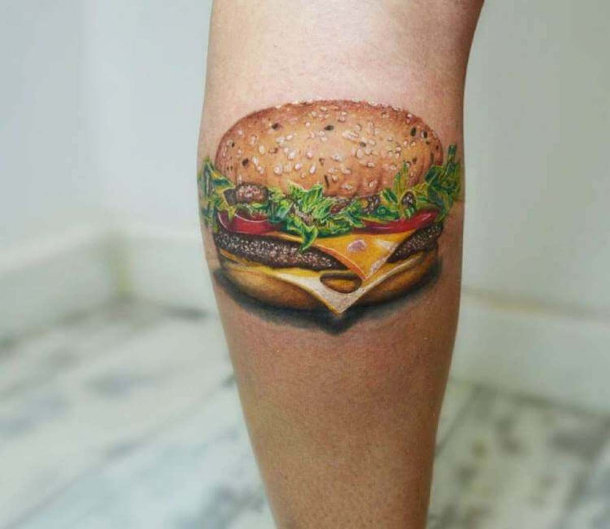 Hmm, kukapa ei rakastaisi sveitsiläistä hampurilaisella? Tatuointi Andrea Morales
