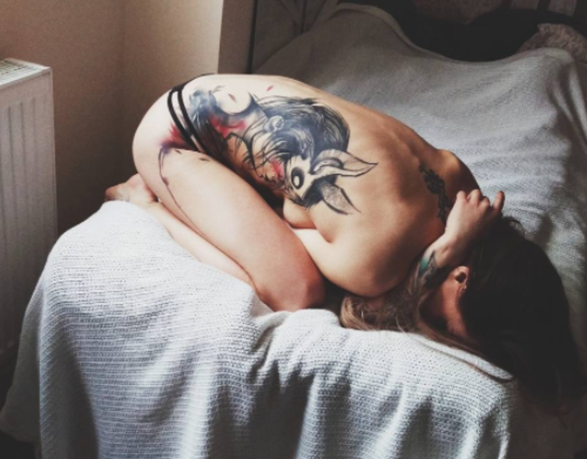 pige på sengen med tatovering i sidestykket