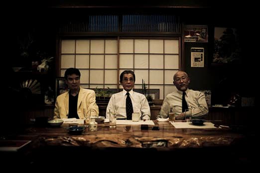 De tre højest rangerede chefer i familien - gudfaderen i midten - poserer til et portræt under en traditionel middag på en restaurant i Kabukicho, Tokyo - 2009