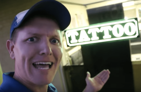 άνδρας που στέκεται μπροστά από το σαλόνι τατουάζ