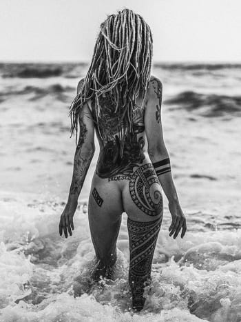 Aurinko, surffaus, hiekka, pelot ja heimojen tatuointi koristettu pusku.