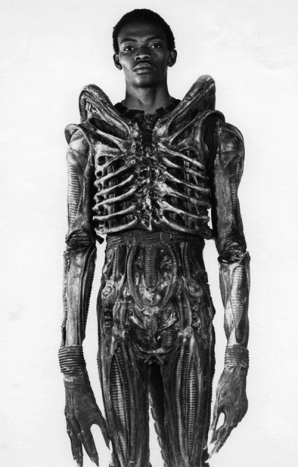 Kuva magen FilmGeek.fr kautta Ridley Scott valitsi käsin nigerialaisen muotoiluopiskelijan Bolaji Badejon tullakseen Alienin nähneiden painajaisten hirviöksi. Toinen erittäin pitkä näyttelijä, Badejo, tuli 7'2 ': n pituudelta, erittäin ohut ja uskomattoman ketterä. Tämä oli ainoa elokuva, jossa Badejo koskaan esiintyi. ”