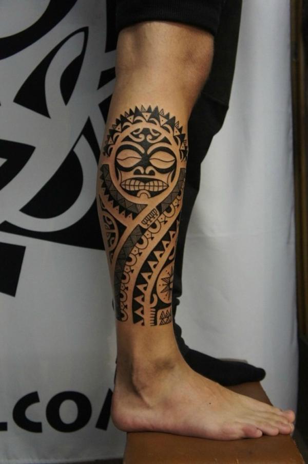 Musta polynesialainen auringon tatuointi oikealla jalalla