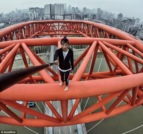 Foto via AsiawireI løbet af de sidste 10 måneder har Wu skaleret skyskrabere rundt i Kina og udført stunts oven på dem, herunder en håndarm på en arm oven på det 70-etagers Sun Moon Light Plaza i Chongqing.