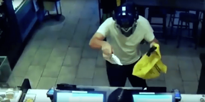 Φωτογραφία μέσω youtube Ο ύποπτος φορώντας μια μπλε μάσκα Transformer πλησιάζει τον πάγκο των Starbucks δείχνοντας ένα ρεαλιστικό όπλο. Κρατάει μια τσάντα στη νεαρή γυναίκα πίσω από τον πάγκο και αρχίζει να κουνά ένα μεγάλο μαχαίρι με απειλητικές κινήσεις. Κάποιος ηλίθιος υπάλληλος των Starbucks χαμογελάει στον Τζέρι και συνεχίζει να καθαρίζει τα τραπέζια.